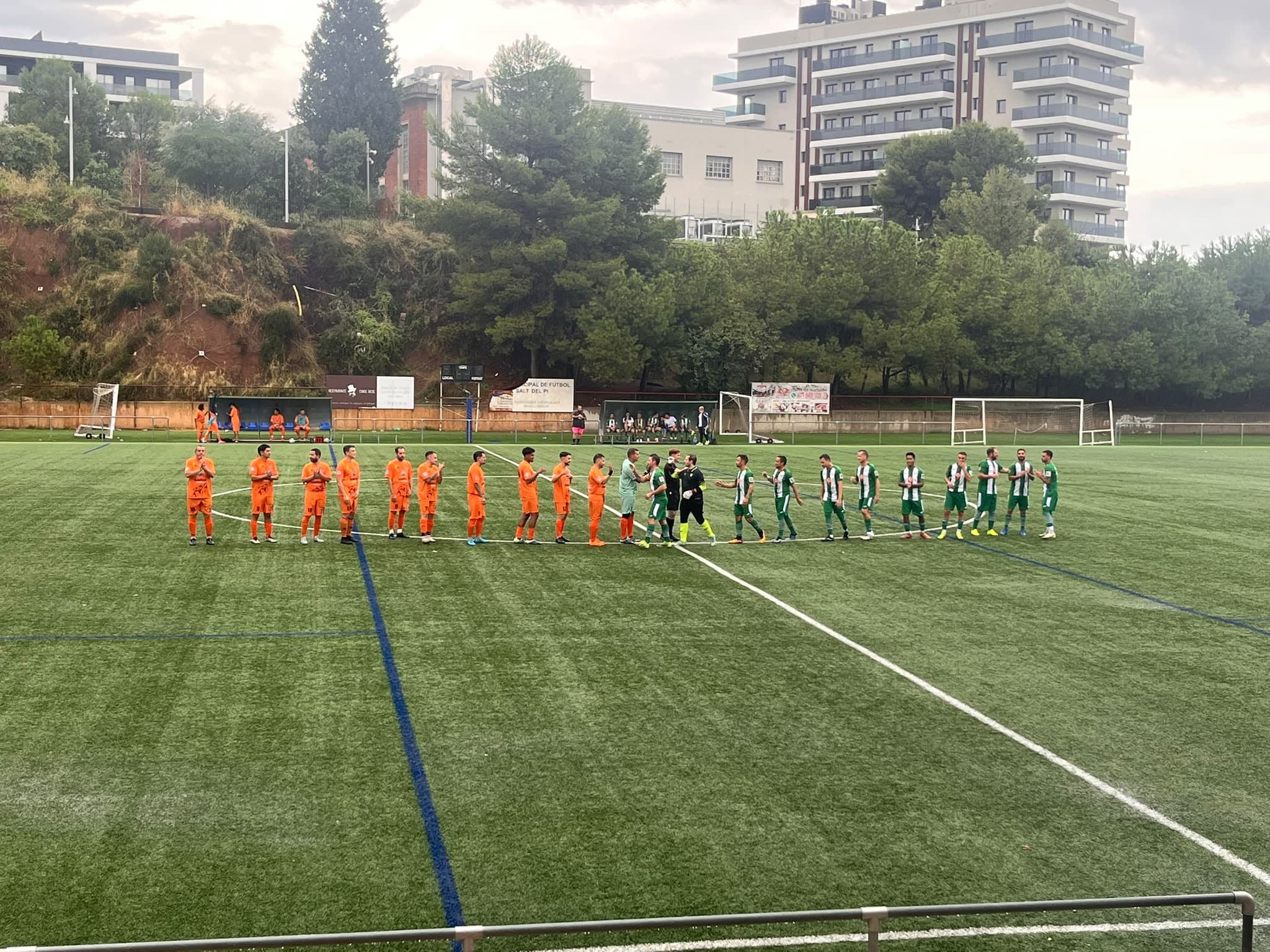 Jugadores de Veteranos de Can Clota-La Plana FC y del equipo rival se saludan sobre el césped antes del partido